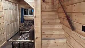 A wooden interior with a staircase, a bench, and a wardrobe. - Cabin 1 on The Willow Reservoir (Hazelhurst)