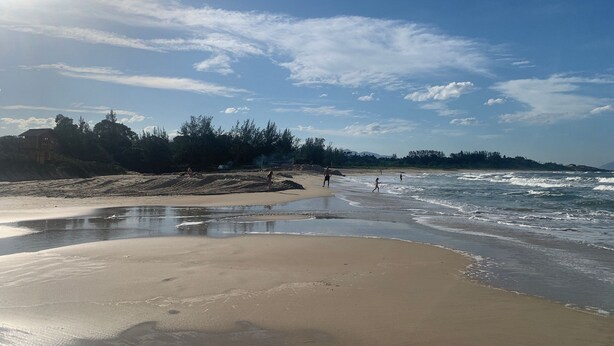 A beach with a sandy shore, waves, and a clear sky. - Paraíso na Gamboa - Garopaba - SC (Garopaba)