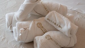 A neatly folded set of towels with embroidered text on a textured bedspread.
