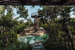 Un parc aquatique doté d’une piscine centrale, d’une tour d’observation et d’une végétation luxuriante tout autour.