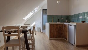 Une cuisine moderne avec une table à manger en bois, des chaises et un lave-vaisselle encastré.