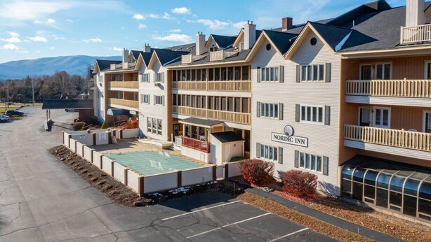 A Nordic Inn hotel with multiple floors, balconies, and a parking area. - Slope Views- Ski Shuttle- Pool & Hot Tub (Lincoln)