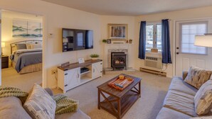 A cozy living room with a fireplace, a television, and a comfortable sofa. - Slope Views- Ski Shuttle- Pool & Hot Tub (Lincoln)