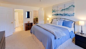 A bedroom with a bed, bedside tables, a wardrobe, and a painting on the wall. - Slope Views- Ski Shuttle- Pool & Hot Tub (Lincoln)