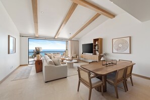 A spacious living area with a balcony, a dining table, and a TV. - Ocean View 3 BR Penthouse with Private Jacuzzi at Puerta del Sol, Cabo San Lucas (Cabo San Lucas)
