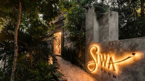 A pathway leading to a building entrance with a sign that reads 'SIWA TULUM.' - Siwa Jungle Solstice C1-102 (Tulum)