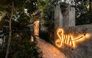 A pathway leading to a building entrance with a sign that reads 'SIWA TULUM.' - Siwa Jungle Solstice C1-102 (Tulum)