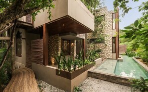 A modern house with a stone facade, a pool, and lush greenery. - Siwa Jungle Rain A2-004 Beach Club Access (Tulum)