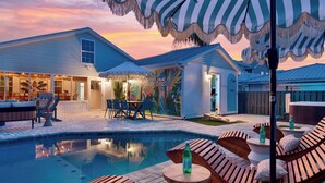 Ein Garten mit Swimmingpool, Gartenmöbeln und einer überdachten Terrasse.
