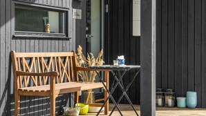 A wooden bench and table outside a building with a dark facade. - Awesome home in Føllenslev with WiFi (Føllenslev)
