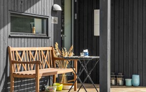 A wooden bench and table outside a building with a dark facade. - Awesome home in Føllenslev with WiFi (Føllenslev)