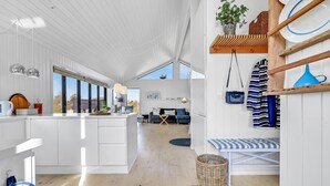 A modern kitchen with white cabinetry, a central island, and a view of the outdoors through large windows. - Awesome home in Føllenslev with WiFi (Føllenslev)