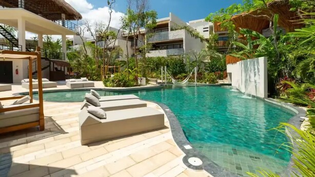A swimming pool area with lounge chairs, a hammock, and a thatched-roof structure. - Near Tulum Beach 2BR –Private Pool & Cenote Access (Tulum)