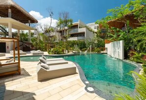 A swimming pool area with lounge chairs, a hammock, and a thatched-roof structure. - Near Tulum Beach 2BR –Private Pool & Cenote Access (Tulum)
