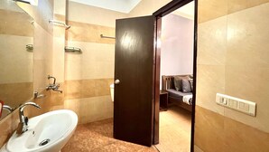 A bathroom with a sink, mirror, and shower. - Skyline Stay (Gurugram)