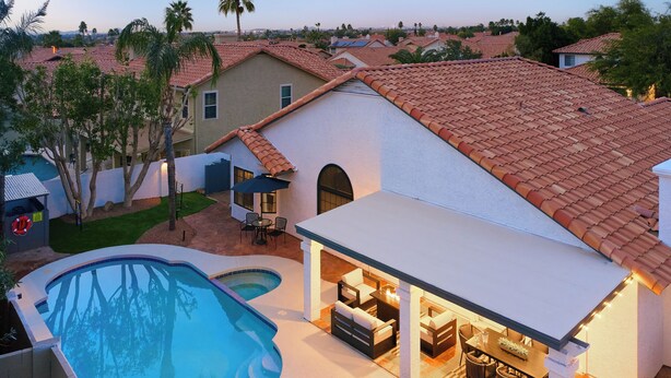 Um imóvel residencial com piscina, área de estar externa e varanda coberta.
