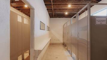 A hallway with lockers, a concrete floor, and exposed wooden beams on the ceiling.