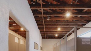 Ein Flur mit Schließfächern, einem Betonboden und freiliegenden Holzbalken an der Decke.