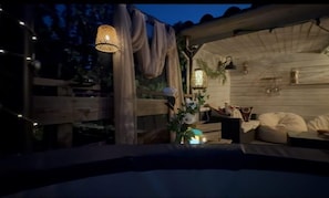 A cozy outdoor seating area with wooden furniture, string lights, and decorative plants. - Magnolia - CANET - Vacation Rental (CANET)
