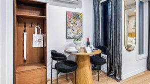 Ein modernes Zimmer mit einem Holzschrank, einem runden Esstisch mit Stühlen, einer McCafé-Tasche, einem McCafé-Schild und einer McCafé-Speisekarte.