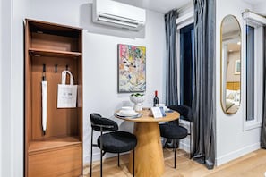 Een moderne kamer met een houten garderobe, een ronde eettafel met stoelen, een McCafé tas, een McCafé bord en een McCafé menukaart.