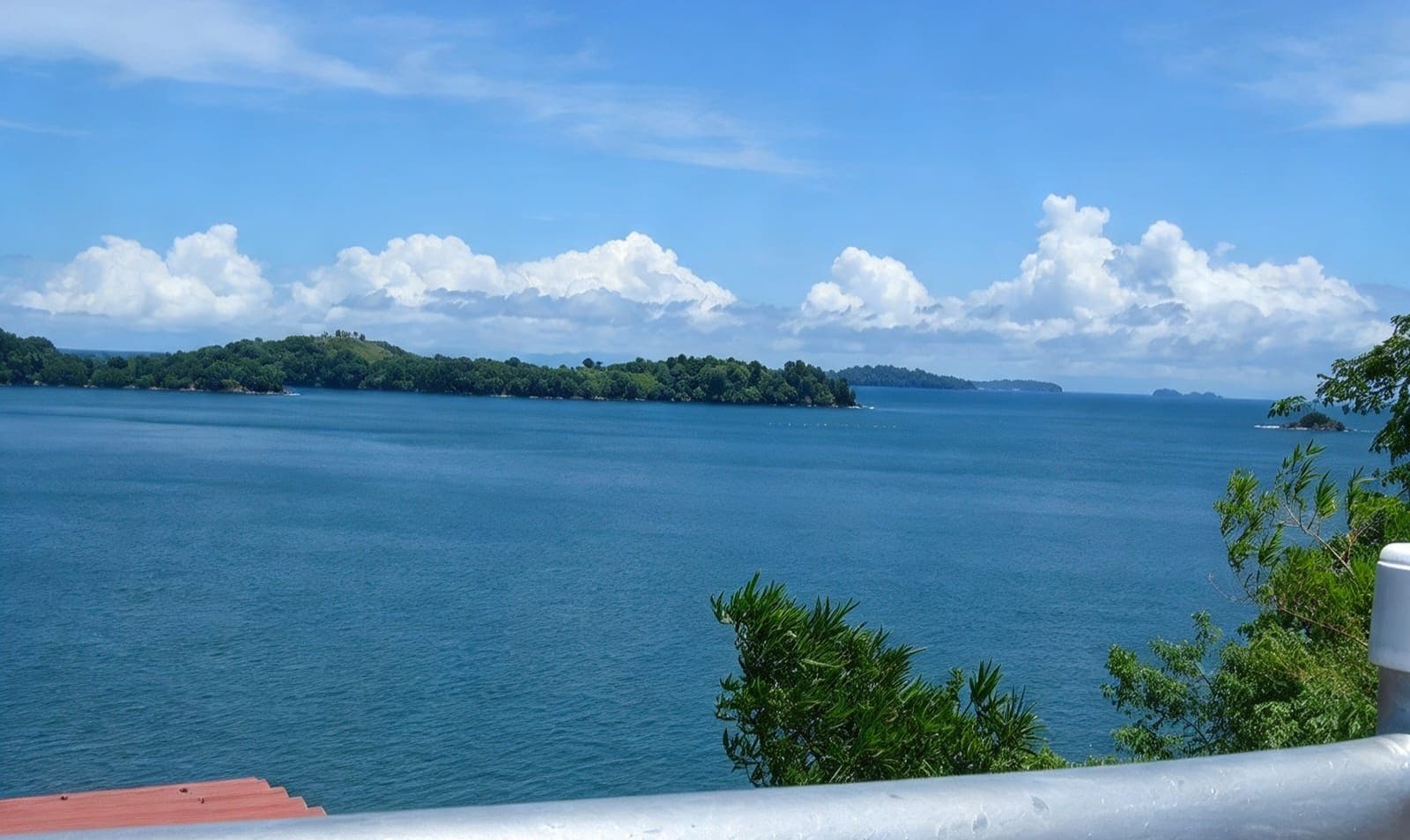 Vista de un cuerpo de agua tranquilo con una masa de tierra distante y un cielo despejado.