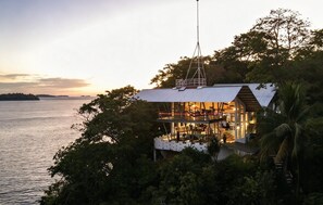 Une propriété située en bord de mer, dotée d’une grande terrasse ouverte avec vue sur la mer, d’un coin repas et d’un intérieur spacieux.