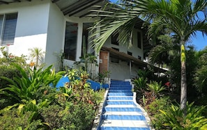 Un escalier menant à un bâtiment à la façade blanche et au toit bleu.
