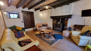 Un salon chaleureux avec une cheminée, des canapés en cuir et un plafond en bois.