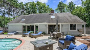 Un jardin avec une piscine, du mobilier d’extérieur et une maison.
