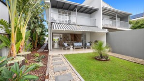 A two-story house with a covered patio, a small garden, and a staircase leading to the upper floor. - Casa Casuarina - Private pool & steps to the beach (Casuarina)