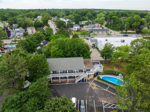 A residential area with a large house featuring a front deck and a swimming pool. - Sunset Suites (Old Orchard Beach)
