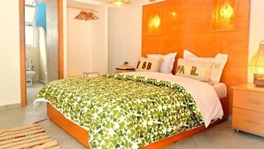 A bedroom with a bed, a wooden headboard, a bedside table, and a nightstand. - Standard Double Room #2 (Tamraght Ouzdar)