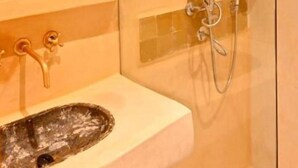 A bathroom with a glass shower enclosure, a wooden shelf above a sink, and a mirror. - Standard Double Room #2 (Tamraght Ouzdar)