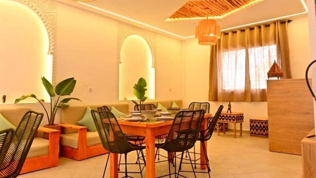 A dining area with a wooden table and chairs, a sofa, and a decorative ceiling. - Standard Double Room #2 (Tamraght Ouzdar)