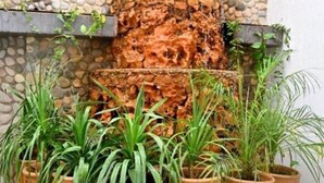 A stone wall with a cascading waterfall feature, surrounded by potted plants. - Superior Double with Terrace #1 (Tamraght Ouzdar,)
