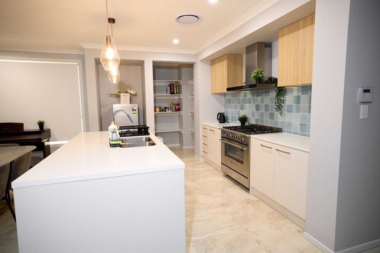 Una cocina moderna con una isla central, electrodomésticos de acero inoxidable y armarios de tonos claros.