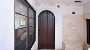 A modern entrance with a dark brown door, a glass door to the left, and a stone wall to the right. - Charming 3-bedroom condo with AC in San Clemente (San Clemente)