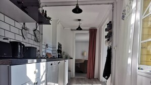 A modern kitchen with white cabinets, a wooden floor, and a ceiling fan. - Vacation home in southern Sweden-Hus Gammal Dam (pet hair free) for up to 6 people (Eringsboda)