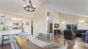A spacious living area with a dining table, chairs, a sofa, and a TV stand. - Coastal townhouse w/ AC, BBQ & shared beach access (San Clemente)
