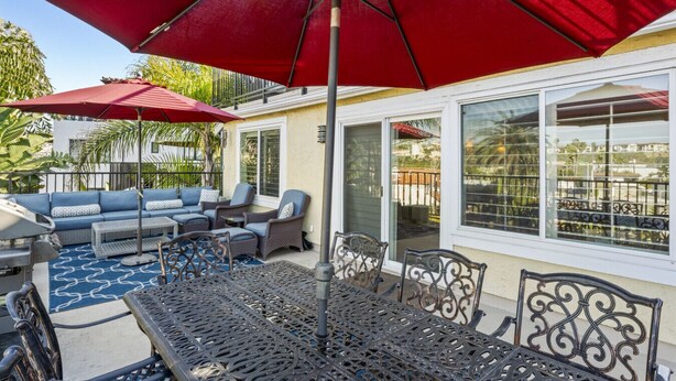 A patio with outdoor furniture, a red umbrella, and a view of the neighborhood. - 6BR coastal escape w/ BBQ & beach access (San Clemente)