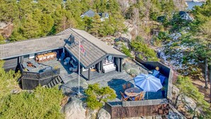 Une cabane dotée d’une terrasse, de meubles d’extérieur et d’un drapeau.