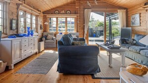 L’intérieur d’un chalet confortable, avec un salon, une cuisine et un coin repas.