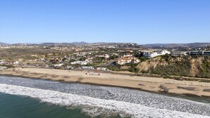 Eine Küstenstadt mit Strand, Häusern und einer Klippe.