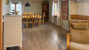 A dining area with wooden chairs and a table, a white refrigerator, and a wooden cabinet with a decorative top. - Cozy home in Oppdal with house a mountain view (Oppdal)