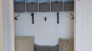Quarto aconchegante com um banco embutido, prateleiras para armazenamento e uma porta.