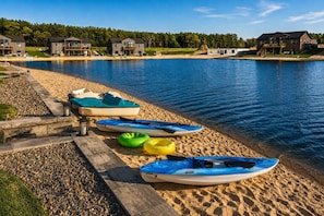 Une propriété au bord du lac, dotée d’un quai, de kayaks et d’une plage de sable.