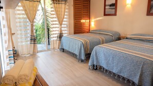 Quarto com duas camas, uma porta de madeira, uma janela com cortinas e uma luminária na parede.