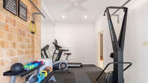 A home gym with exercise equipment including a treadmill, elliptical, and free weights. - Private Jetty. Waterfront. Sleeps 10 (Koolewong)