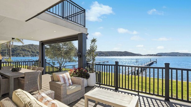 A deck with outdoor furniture, a railing, and a view of the water. - Private Jetty. Waterfront. Sleeps 10 (Koolewong)